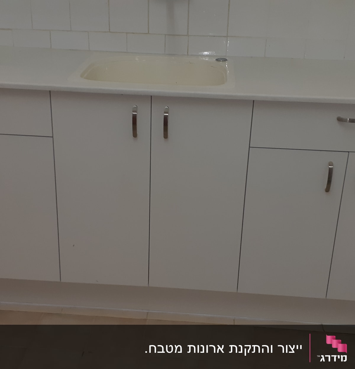 ארון מטבח לבן עם ידיות מתכת וכיור